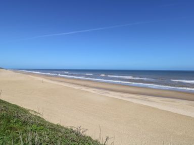 A beach with sand and ocean waves at Sandy Snug in Bacton