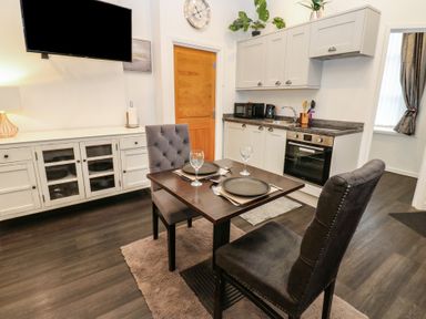 A kitchen with a dining table and chairs at The Railway Apartment in Hexham