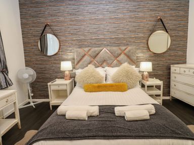A bedroom with a bed and nightstands at The Railway Apartment in Hexham