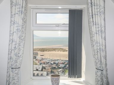 A view from a window showing the sea and boats at The Ingle in Barmouth