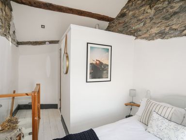 A bedroom with a bed and a picture on the wall at The Ingle in Barmouth