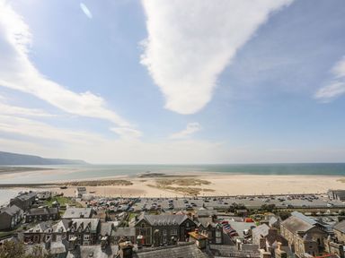 A view of a beach and parking area at The Ingle in Barmouth