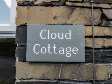 A sign for Cloud Cottage on a stone wall in Ambleside