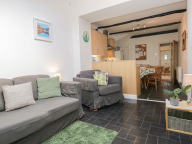 A living room with a sofa and dining area at Cloud Cottage in Ambleside