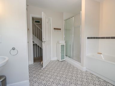 A bathroom with a shower, bathtub, and sink at Cloud Cottage in Ambleside