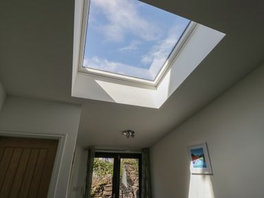 A room with a skylight, window, and door at Cloud Cottage in Ambleside