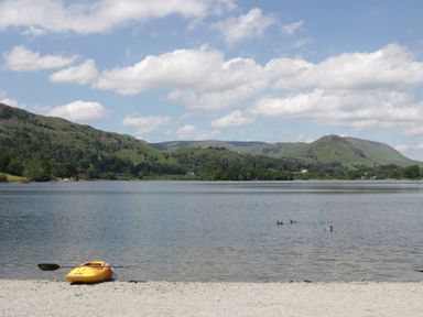 A kayak on a lake with ducks swimming at Cloud Cottage in Ambleside