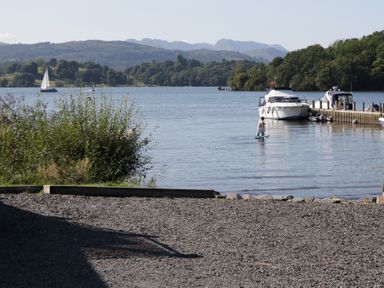 A view of a lake with boats and a paddleboarder at Cloud Cottage in Ambleside