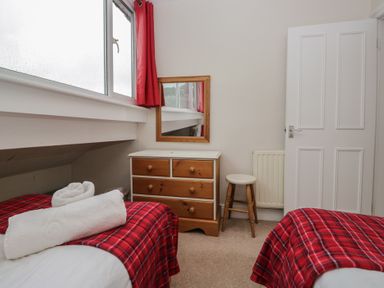 A bedroom with two beds and a mirror at Cloud Cottage in Ambleside