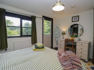 A bedroom with a bed and desk at Moon Cottage near White Cross Bay Holiday Park near Troutbeck Bridge