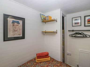 A bedroom with shelves and towels at Moon Cottage White Cross Bay Holiday Park near Troutbeck Bridge