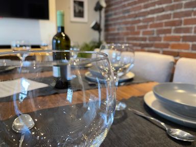 A dining table set with glasses and a wine bottle at Dolwen in Caernarfon