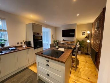A kitchen with an island and seating at Dolwen in Caernarfon
