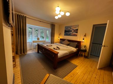A bedroom with a bed and window at Dolwen in Caernarfon