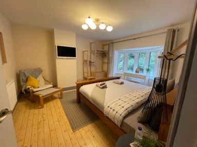 A bedroom with a bed and chair at Dolwen in Caernarfon