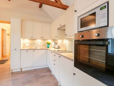 A kitchen with cabinets, sink, and appliances at The Old Sorting Office