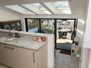 A kitchen with a sink and open glass door leading to a deck at 36 Crowthers Hill in Dartmouth