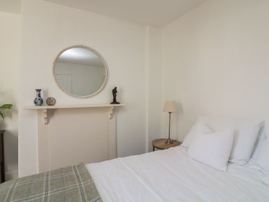 A bedroom with a bed, lamp, and mirror at 36 Crowthers Hill in Dartmouth