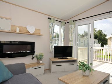 A living room with a television and a sofa at Eden Way 47