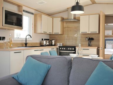 A kitchen with a stove and refrigerator at Eden Way 47