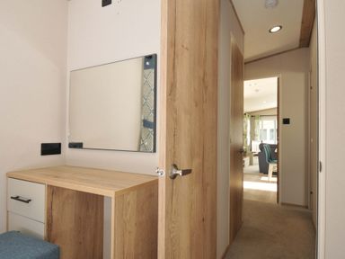 A hallway with a desk and mirror at Eden Way 47