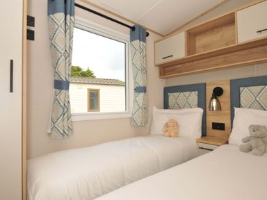 A bedroom with two beds and a window at Eden Way 47