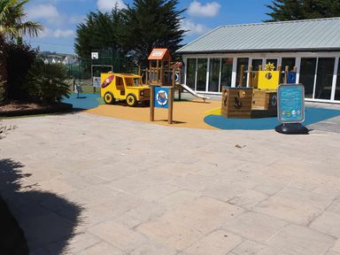An outdoor play area with a slide and a yellow toy truck at Par Sands Holiday Park - Par