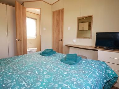 A bedroom with a bed and a television at The Oakley in Par