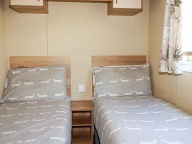 A bedroom with two beds and a bedside table at The Oakley in Par