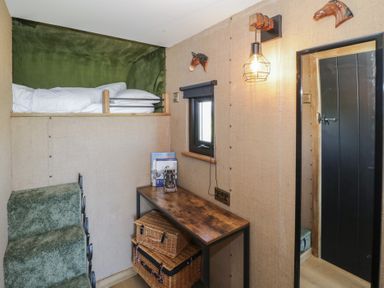A bedroom with a bunk bed and a desk at GiGi's Horsebox Evesham
