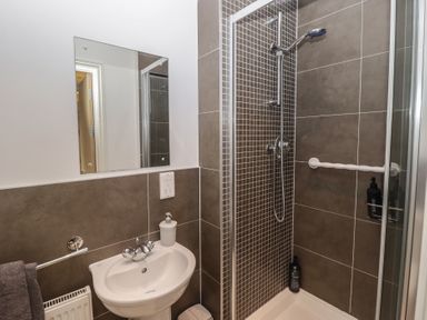 A bathroom with a shower and sink at Awel y Môr in Burry Port