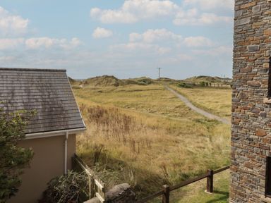 An outdoor view of a path and grassy area near a house at Awel y Môr Burry Port