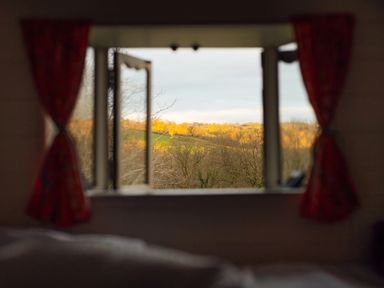 A window with open curtains and a view of a landscape at Goldfinch in Launceston