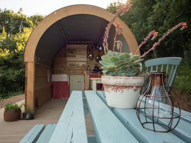 An outdoor living area with a wooden table and plants at Goldfinch in Launceston