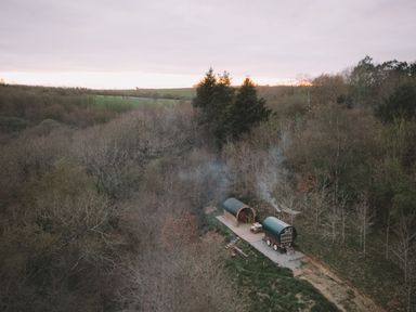 Two cabins in a wooded area with smoke rising at Goldfinch, Launceston