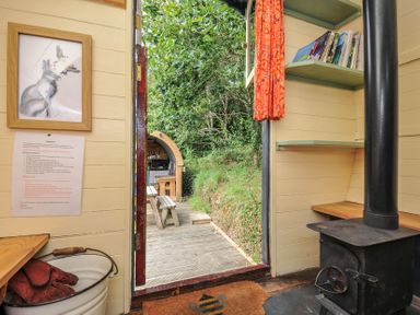 An interior view with a stove and shelf at Goldfinch Panson Mill near Ashwater