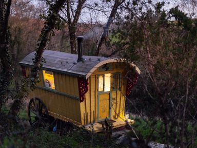 A yellow caravan with a chimney in a rural setting at Prudence in Launceston