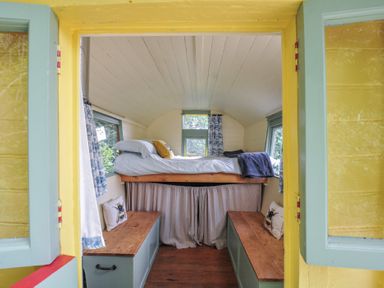 A sleeping area with a bed and bench at Prudence in Panson Mill near Ashwater