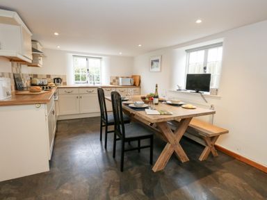 A kitchen with dining table and chairs at Bubbs Cottage 