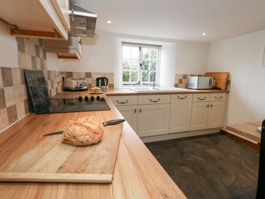 A kitchen with a countertop, sink, and appliances at Bubbs Cottage
