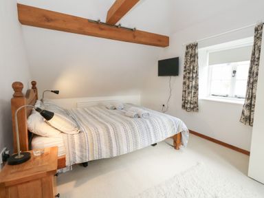 A bedroom with a bed and a tv at Bubbs Cottage