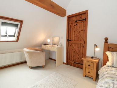 A bedroom with a desk and chair at Bubbs Cottage