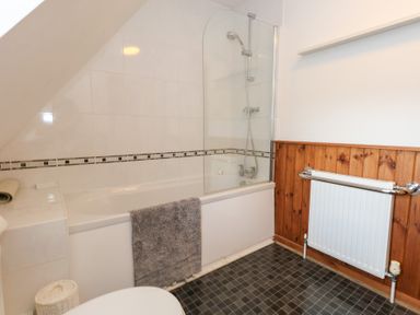A bathroom with a bathtub and shower at Bubbs Cottage