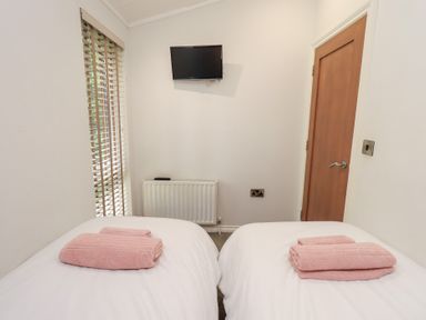 A bedroom with twin beds and a television at Laughing Duck in Troutbeck Bridge