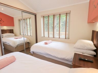 A bedroom with two beds and a wardrobe at Laughing Duck in Troutbeck Bridge