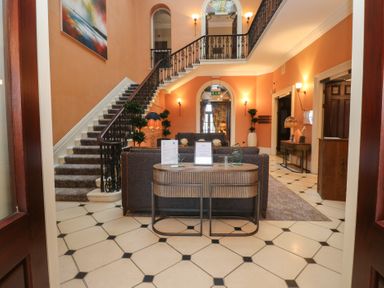 A lobby with a staircase, sofa, and table at Costal Lodge at Seaham Hall Seaham