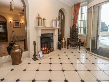 A lobby with a fireplace and armchair at Costal Lodge at Seaham Hall in Seaham