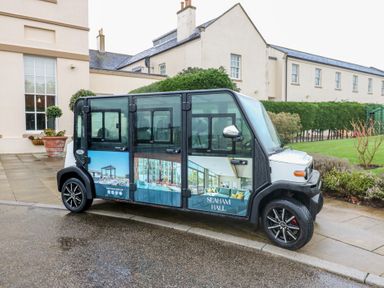 An electric vehicle with signage parked outside Seaham Hall in Seaham