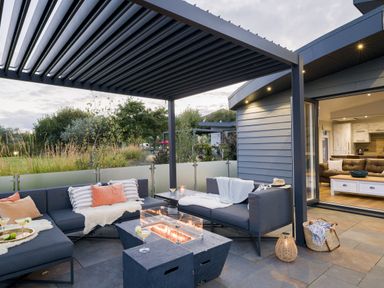An outdoor seating area with a fire pit and sofa at Costal Lodge at Seaham Hall Seaham