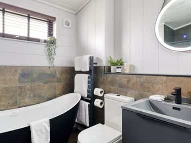 A bathroom with a bathtub and sink at Costal Lodge at Seaham Hall in Seaham
